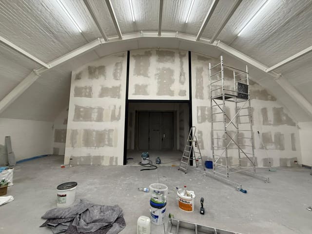 Barrel-vaulted attic ceiling under construction with scaffold tower