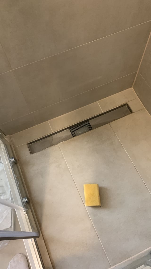 Overhead view of a tiled shower floor and drain